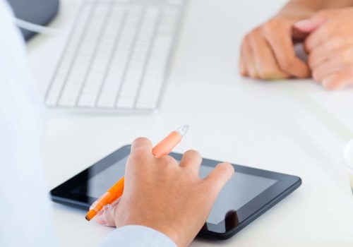 Two business woman working in office with digital tablet.